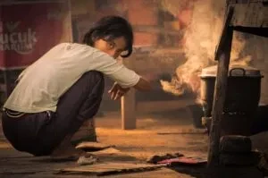 印尼女孩以煤炉准备早餐的纪实影像
